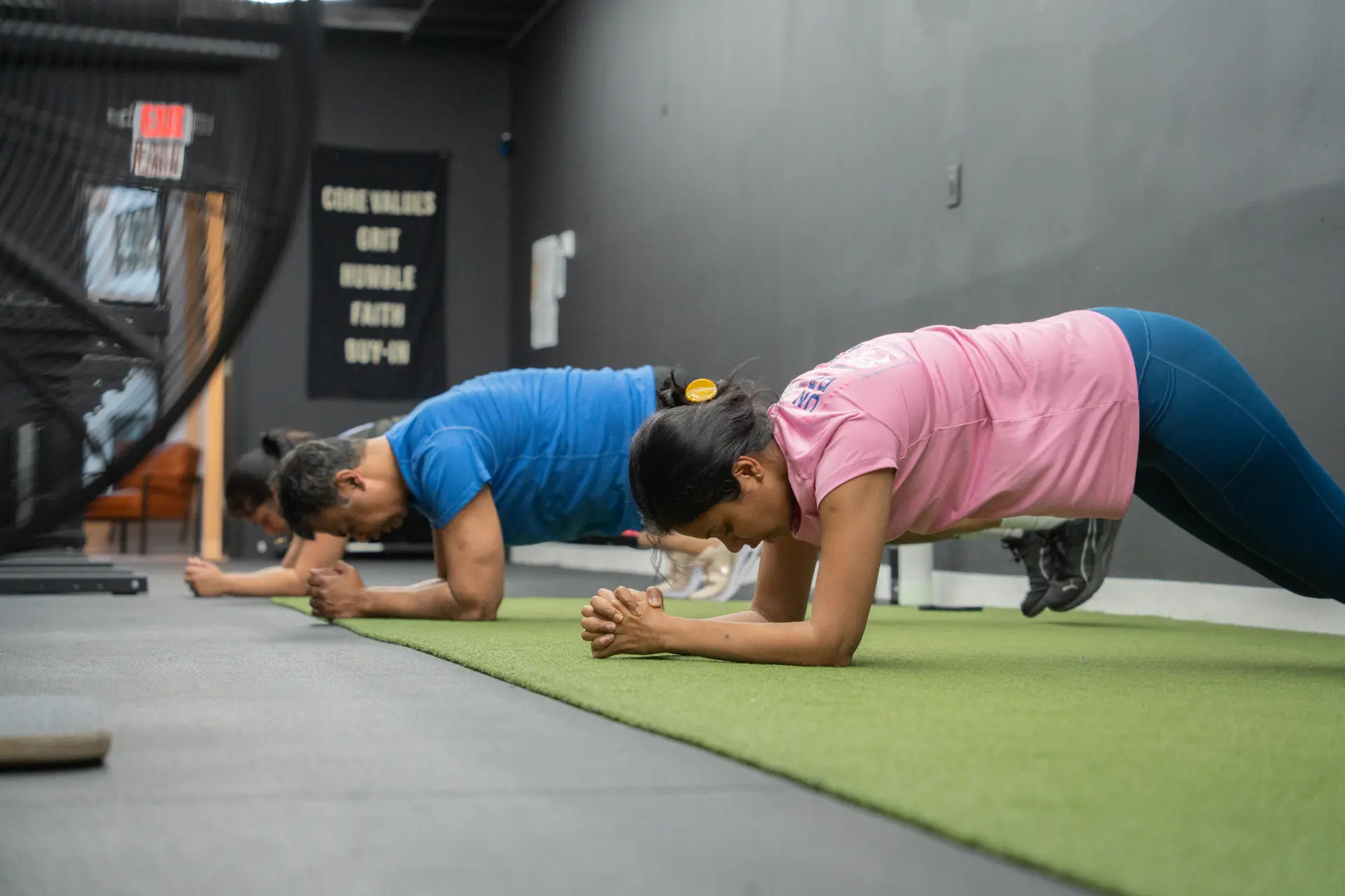 Dyamond Fitness members holding a plank during a coached small-group training session