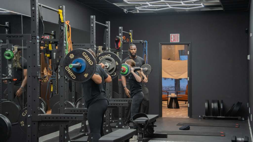 Members squatting in the Dyamond Fitness strength training racks